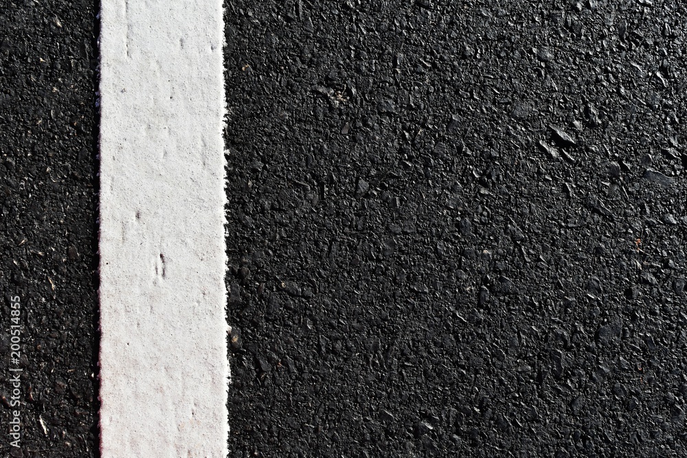 Fototapeta premium dirty white line on surface of old asphalt in countryside