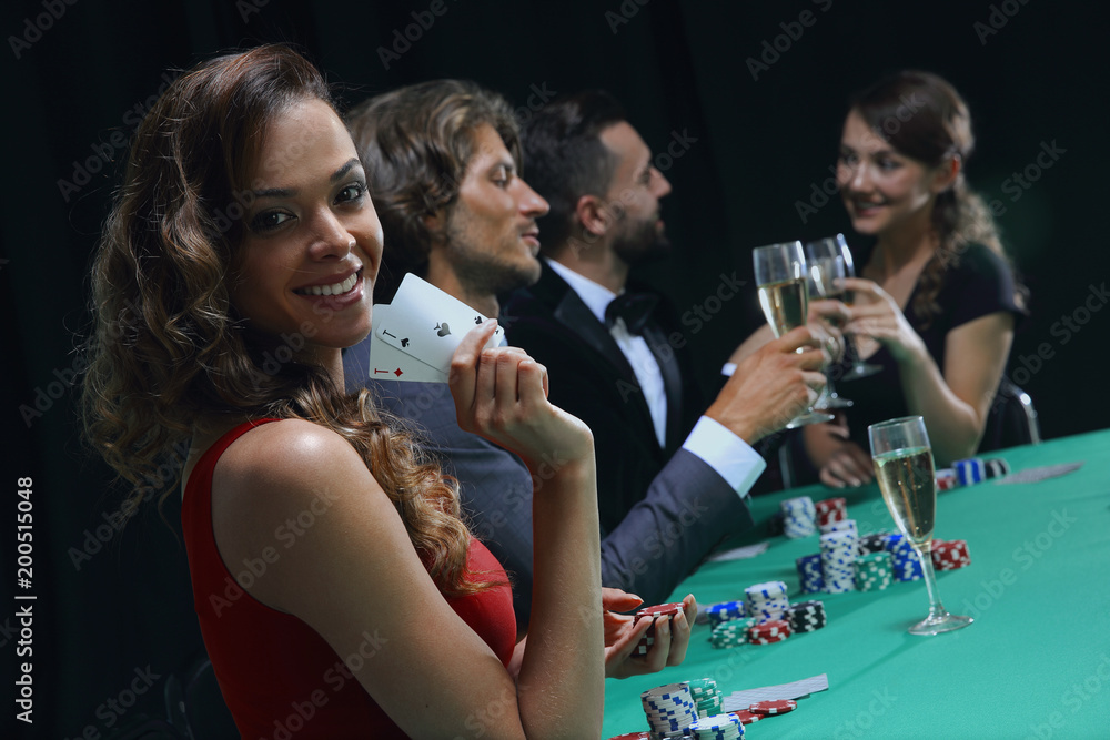 young brunette woman playing poker on black background