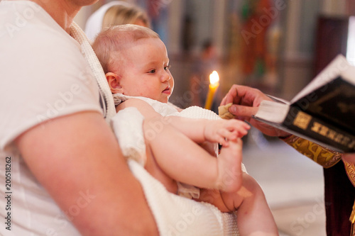 Konstfotografi Priest touches the feet of newborn baby during the ceremony of epiphany