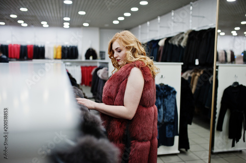 Elegance blonde girl in fur coat at the store of fur coats and leather jackets. © AS Photo Family