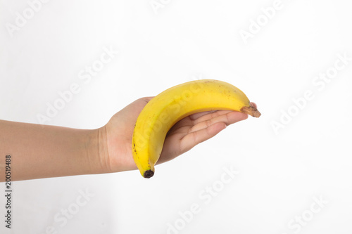 Hand holds a banana isolated on white background.