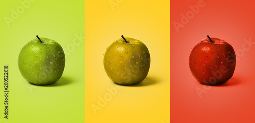 Set of wet green, yellow and red apples on the same color background like apple. photo