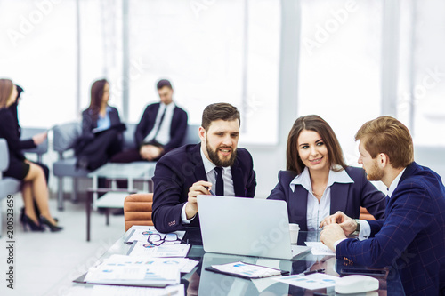 employees of the company work on laptop with information on the development of the company