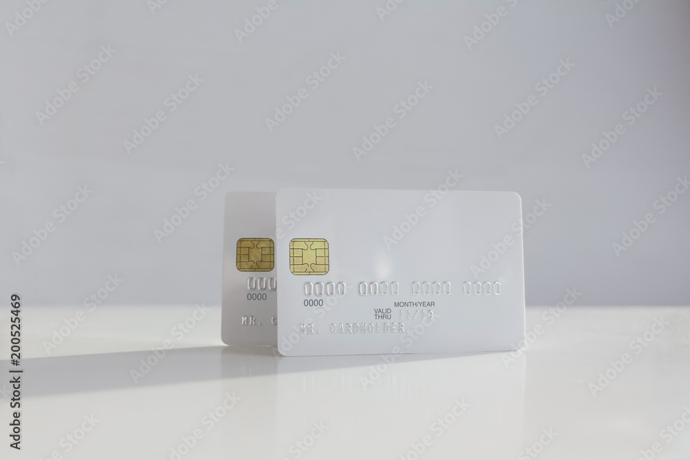 Two white blank credit card on soft blurred background Two white blank credit card on soft blurred background