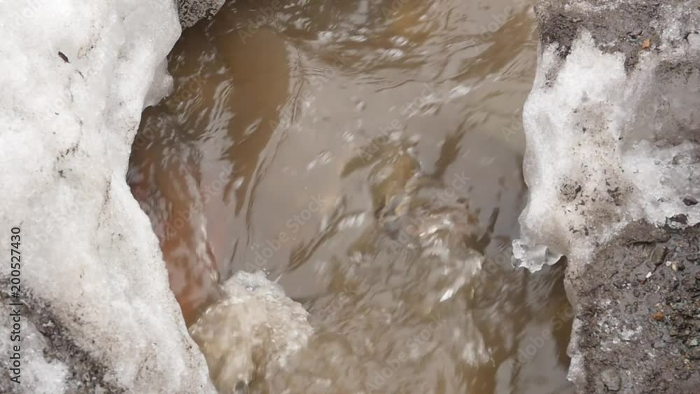 small river flows through the ice in springtime. slow motion small river flows through the ice in springtime. slow motion