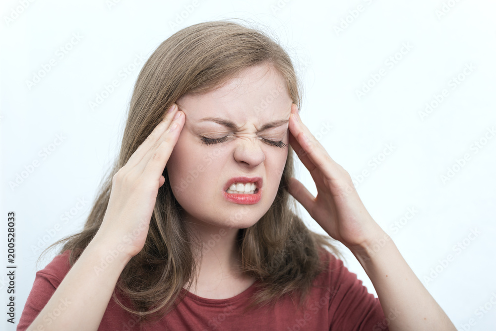 Young caucasian woman because of a headache keeps fingers on temples Young caucasian woman because of a headache keeps fingers on temples