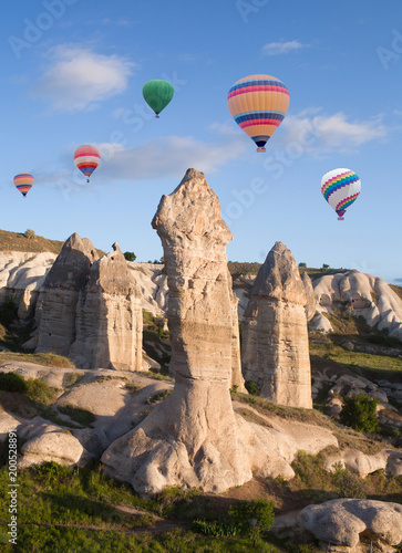 Colorful hot air balloons flying over unique geological formations in Cappadocia, Anatolia, Turkey © Zzvet
