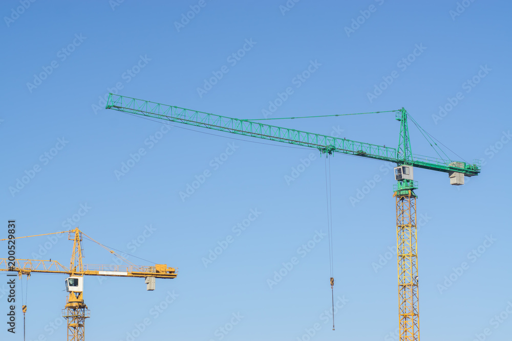 Construction cranes on the background of clear blue sky