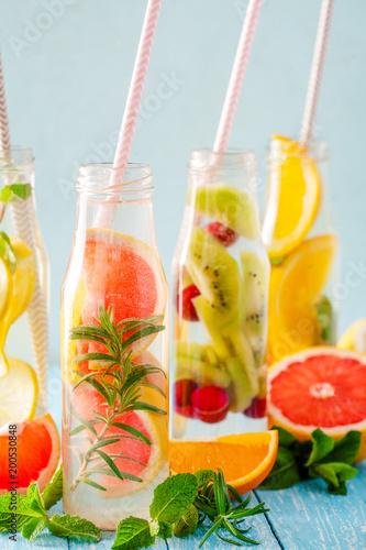 Variety of fruit infused detox water in small bottles. Set of refreshing summer drinks. Healthy diet eating concept. photo