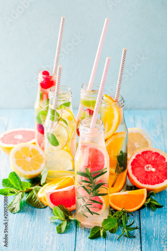 Foto Variety of fruit infused detox water in small bottles