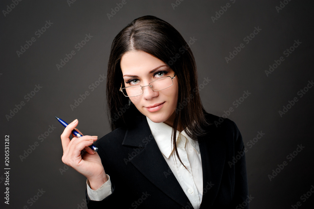 young beautiful secretary posing with pen looking away wearing glasses young beautiful secretary posing with pen looking away wearing glasses