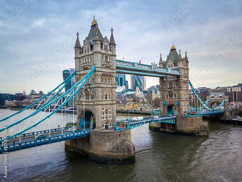 London  England - Aerial view of the iconic Tower Bridge and Tower of London on a cloudy moring with skyscrapers of the financial Bank District at background