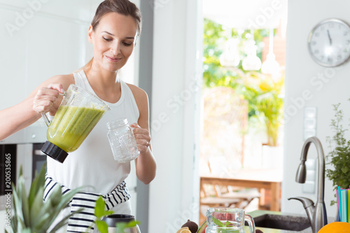 Woman pouring coctail into jar
