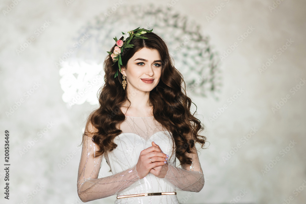 Portrait of a beautiful bride. Wedding make-up. Volume hairstyle. The curls. Brunette in a beautiful interior waiting for the groom Portrait of a beautiful bride. Wedding make-up. Volume hairstyle. The curls. Brunette in a beautiful interior waiting for the groom