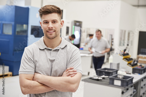 Portrait Of Male Engineer On Factory Floor Of Busy Workshop photo