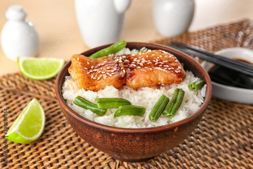 Fish fillet served with rice and green beans on wicker coaster Fish fillet served with rice and green beans on wicker coaster
