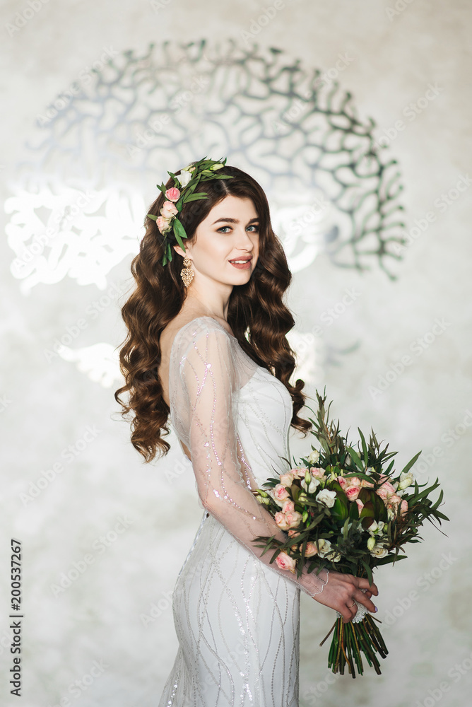Portrait of a beautiful bride. Wedding make-up. Volume hairstyle. The curls. Brunette in a beautiful interior with wedding bouquet Portrait of a beautiful bride. Wedding make-up. Volume hairstyle. The curls. Brunette in a beautiful interior with wedding bouquet