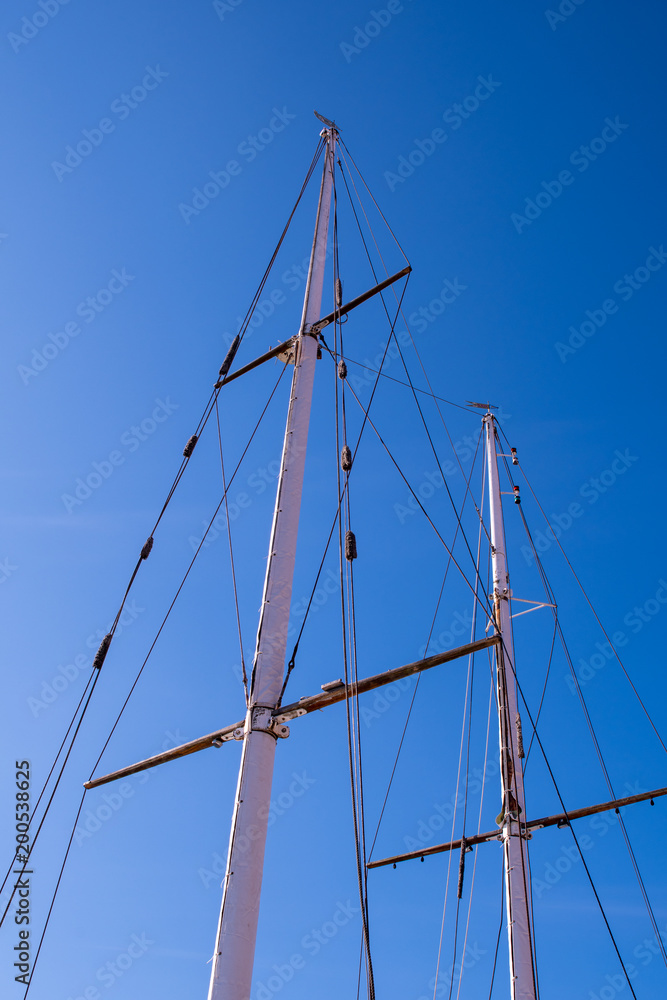 Masts and rigging on a private yacht against a clear blue sky Masts and rigging on a private yacht against a clear blue sky