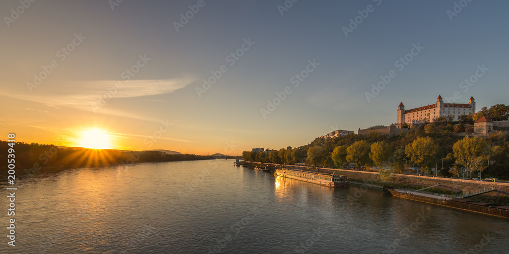 The sun sets to the West along the mighty river Danube as the famous Slovakian Castle stands proud on his hill in Bratislava