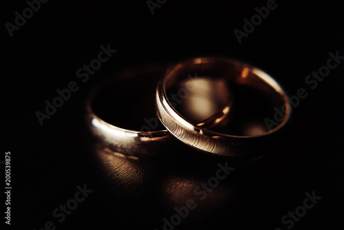 Macro photo of gold wedding rings. Black background. Professional photo session. Professional photo studio