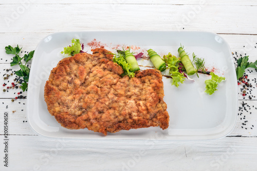 Fried schnitzel from pork. Top view. On a wooden background. Copy space.