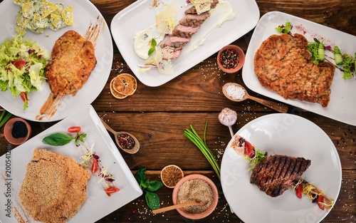 A selection of juicy steaks and schnitzels. Meat. Top view. On a wooden background. Copy space.