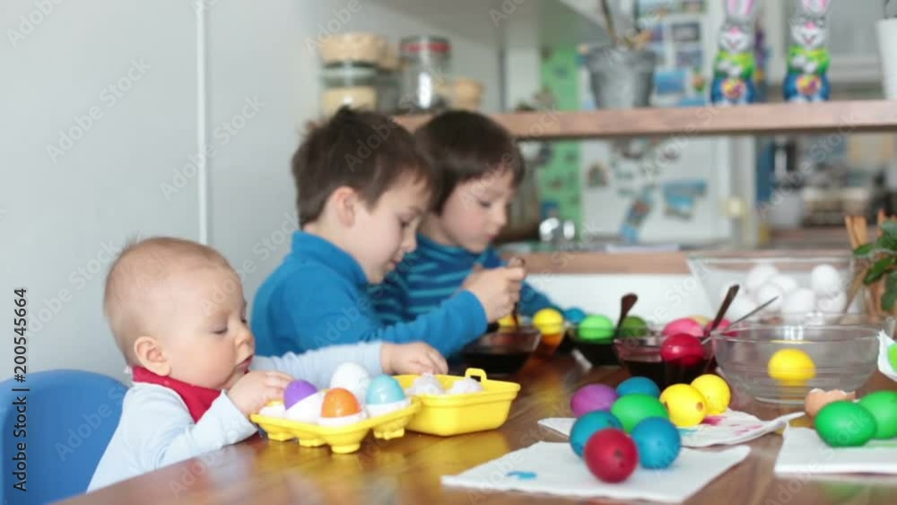 Three children, coloring and painting easter eggs at home for the holiday Three children, coloring and painting easter eggs at home for the holiday