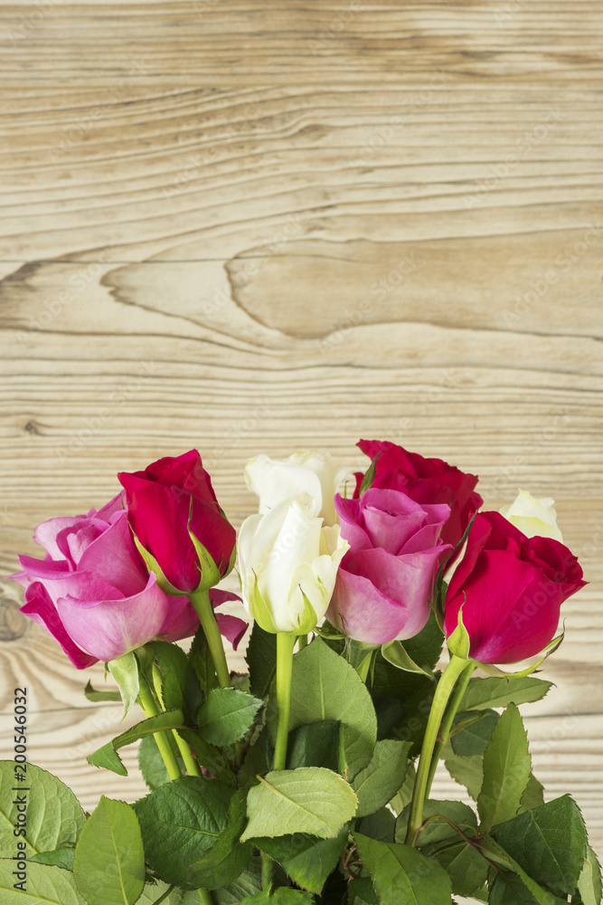 Ein Blumenstrauß mit Rosen vor einem Holz Hintergrund