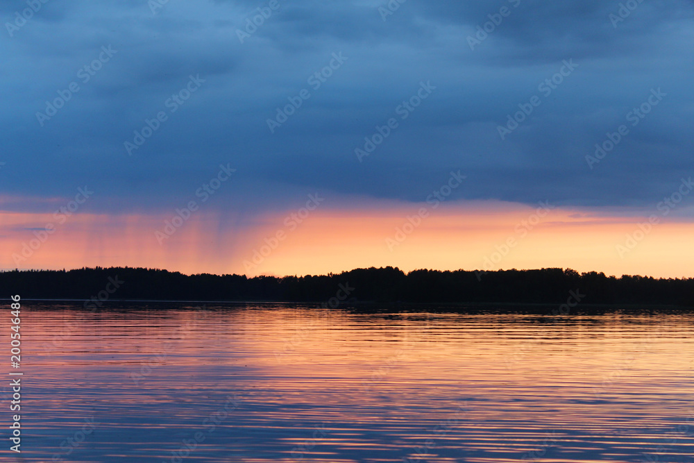 Sunset on the Vuoksa lake. It is small rain on the horizon.
