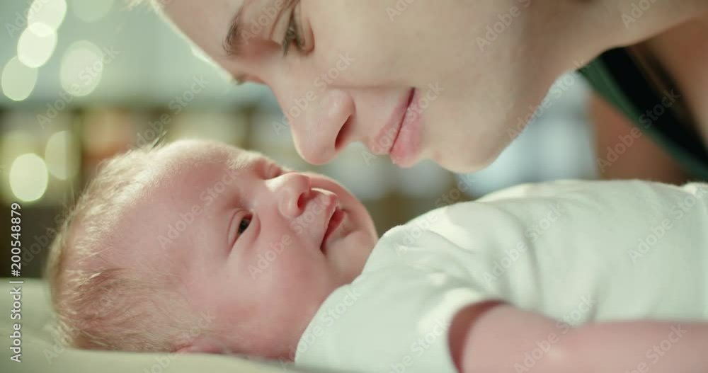 4k.Happy mother and her newborn baby kissing and hugging. Resting in bed together. Maternity concept. Parenthood. Motherhood Beautiful Happy Family Slow Motion 4k.Happy mother and her newborn baby kissing and hugging. Resting in bed together. Maternity concept. Parenthood. Motherhood Beautiful Happy Family Slow Motion