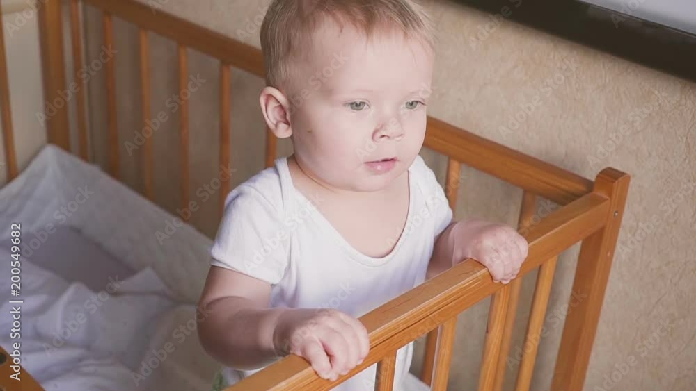 Kid in the crib looks around speaks, jumps and smiles. Kid in the crib looks around speaks, jumps and smiles.