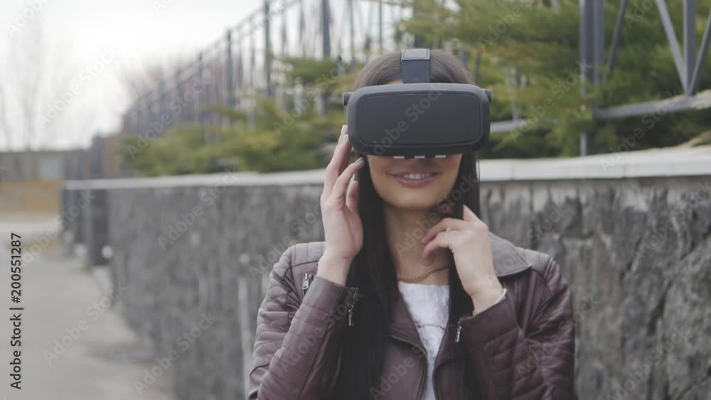 young beautiful woman getting experience in using VR-headset or virtual reality headset outdoor young beautiful woman getting experience in using VR-headset or virtual reality headset outdoor