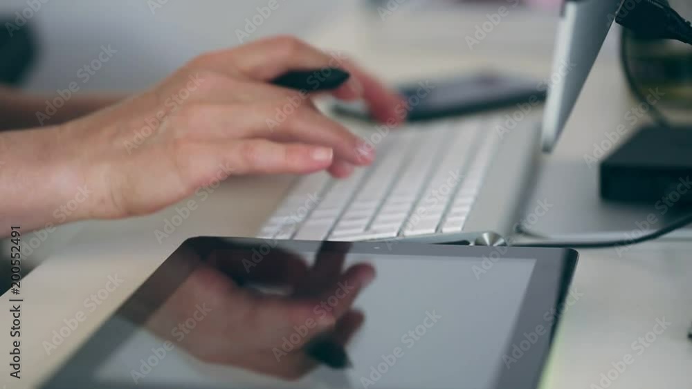 Woman working with a phone, desktop pc and graphic tablet Woman working with a phone, desktop pc and graphic tablet
