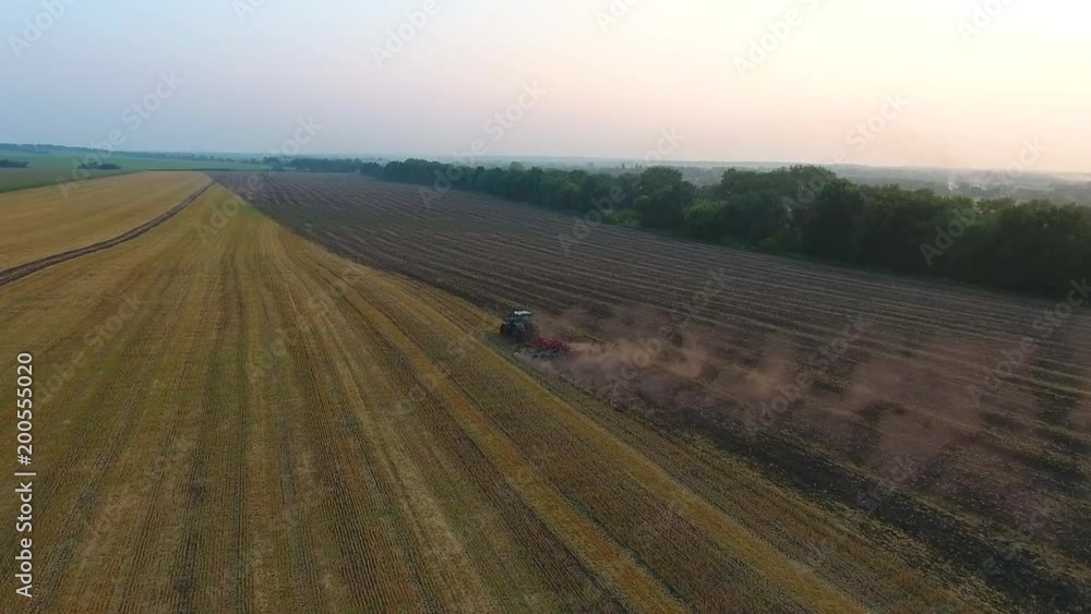 Agricultural machinery plowing farming field. Aerial view cultivation. Tractor preparing soil Agricultural machinery plowing farming field. Aerial view cultivation. Tractor preparing soil