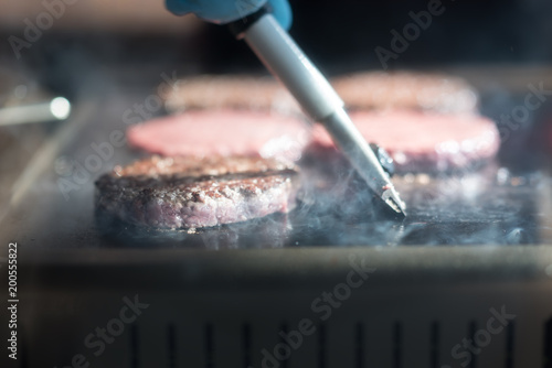 Hamburger cutlet frying on pan.Natural meet loaf pieces cooking in the kitchen.Burger sandwich meat being cooked with a lot of white smoke from a fat and oil.