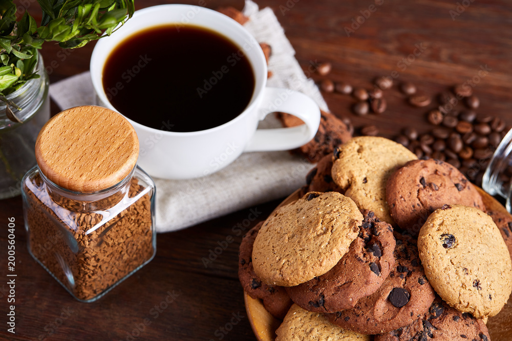 Side view of a plate of chocolate chip cookies on a white plate on homespun tablecloth, selective focus Side view of a plate of chocolate chip cookies on a white plate on homespun tablecloth, selective focus