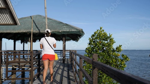 Philipina woman take mobile photo on pier at waterfront Puerto Princesa  photo