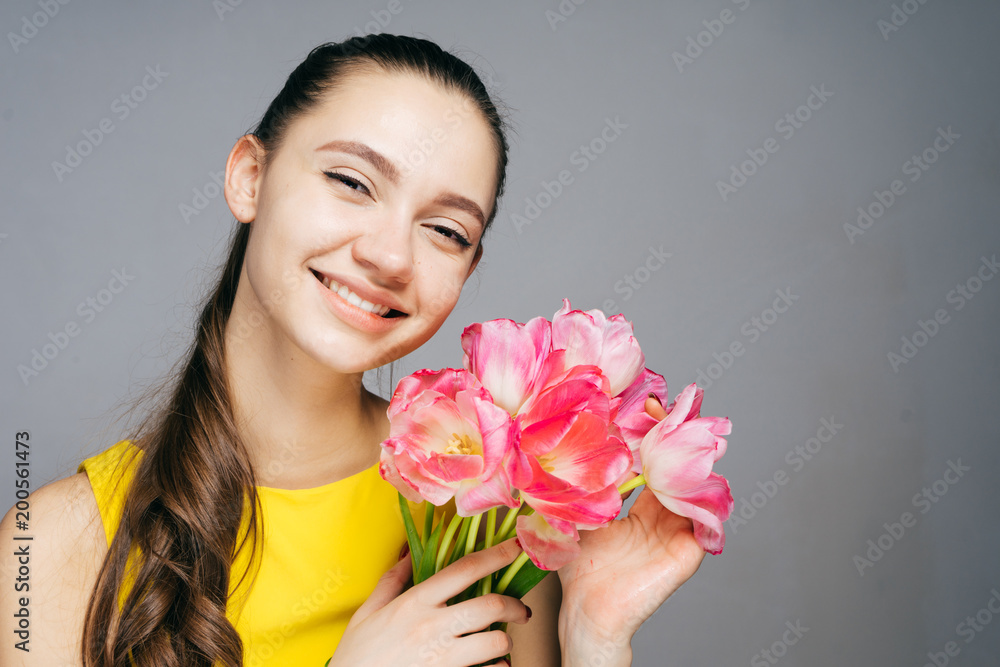 happy smiling girl in yellow dress holding a bouquet of fragrant pink flowers, enjoying spring happy smiling girl in yellow dress holding a bouquet of fragrant pink flowers, enjoying spring