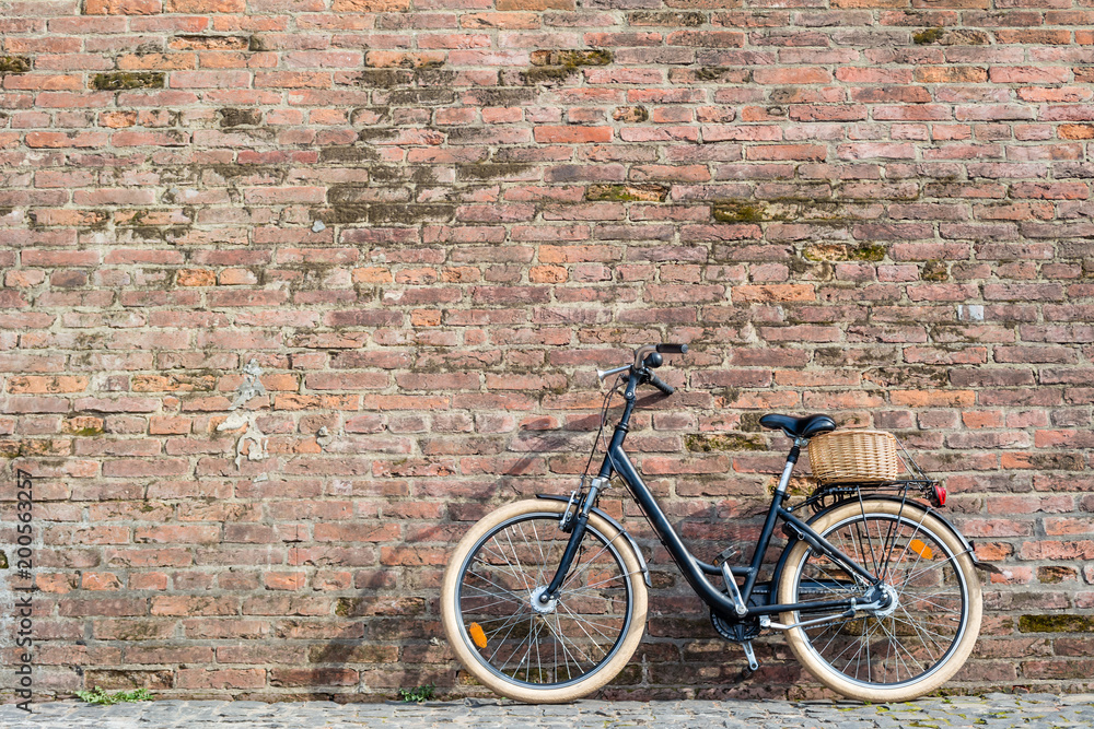 Black retro vintage bicycle with old brick wall.