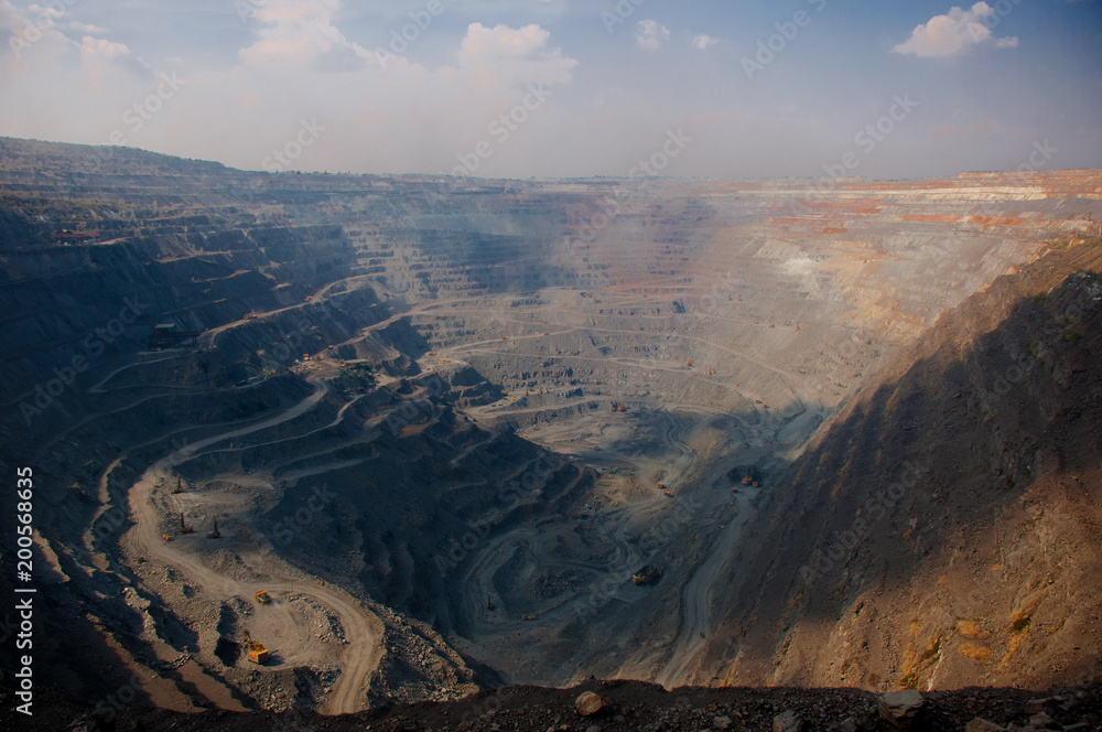 Extraction of iron ore by open method. Panoramic view. The biggest quarry in Europe. Dumper, excavator, bulldozer, diver, tractor, tractor extracts ore.