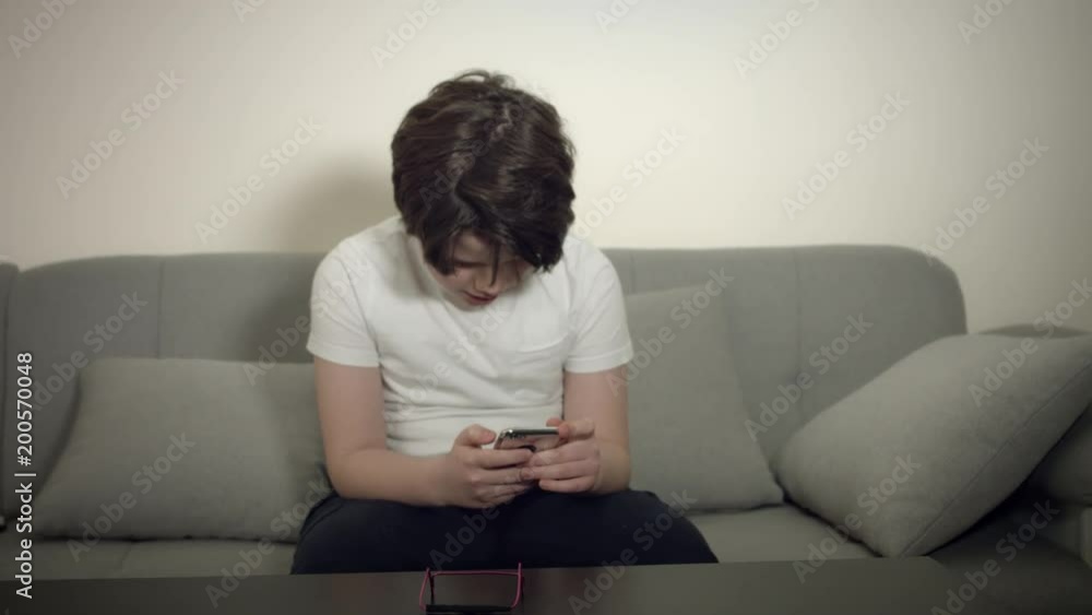 4K Tech-Addicted Child Watching his Phone on the Couch 4K Tech-Addicted Child Watching his Phone on the Couch