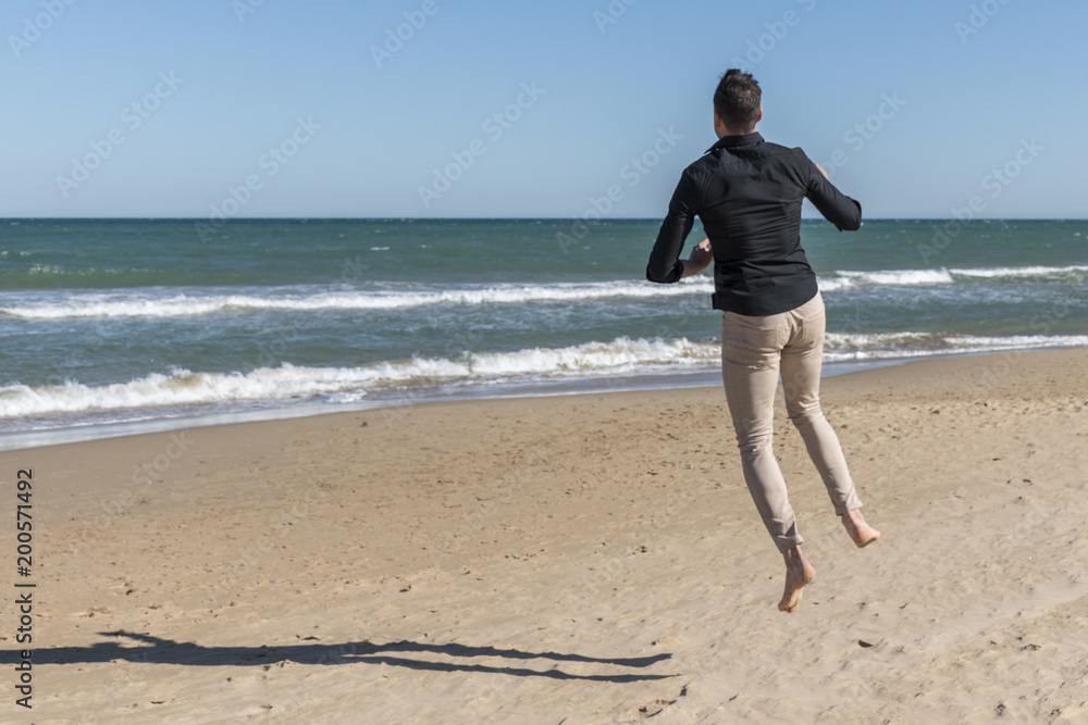 Man jumping happily on the beach