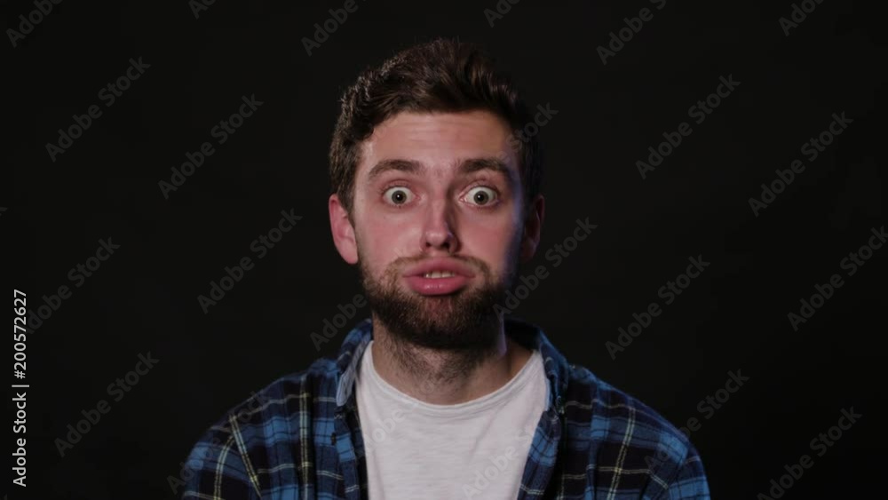 A young man playing a fool against a black background. Close-up shot A young man playing a fool against a black background. Close-up shot