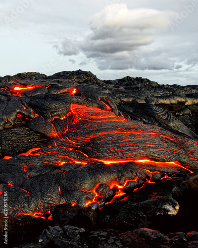 Fotografi A lava flow emerges from an earth column and flows in a black volcanic landscape