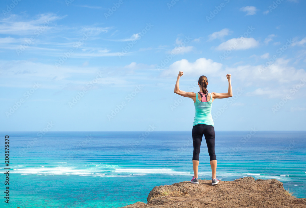 Strong woman flexing outdoors. Female power, strength, and self motivation concept.  