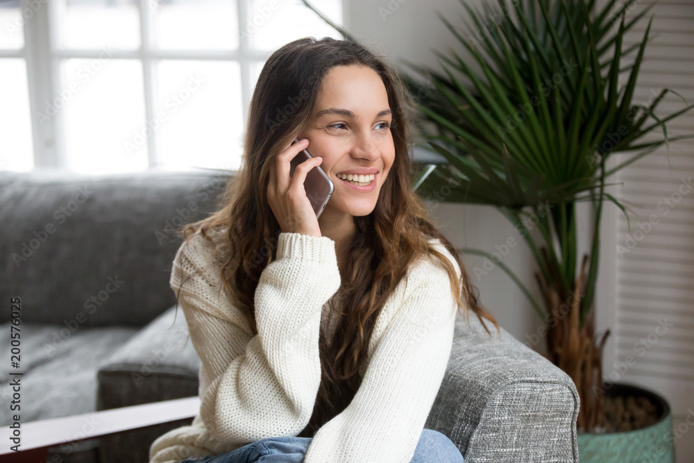 Smiling millennial mestizo woman talking on the phone at home, happy young girl holds cellphone making answering call, attractive teenager having pleasant conversation chatting by mobile with friend Smiling millennial mestizo woman talking on the phone at home, happy young girl holds cellphone making answering call, attractive teenager having pleasant conversation chatting by mobile with friend