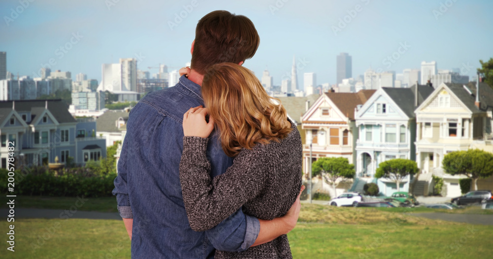 Couple embracing and being affectionate in painted ladies neighborhood