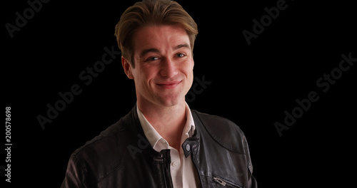 Male in leather jacket winking at camera on black background with copyspace