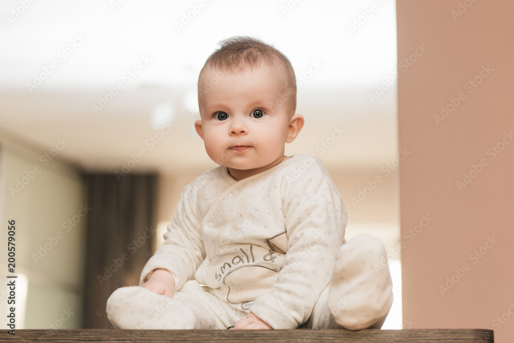 childhood, babyhood and people concept - happy little baby boy or girl sitting at home childhood, babyhood and people concept - happy little baby boy or girl sitting at home