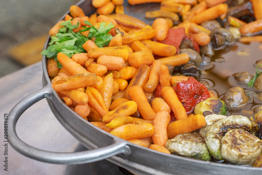 Carrot baby, mushrooms and other vegetables baked in a large frying pan Carrot baby, mushrooms and other vegetables baked in a large frying pan